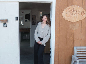 Sophie Mutlu standing in the doorway of her studio, smiling gently before departing on her journey to Germany.